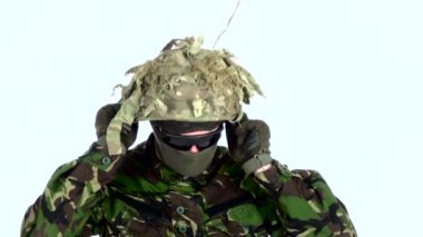 Asker kafasına bir kask takıyor. Beyaz backgraund