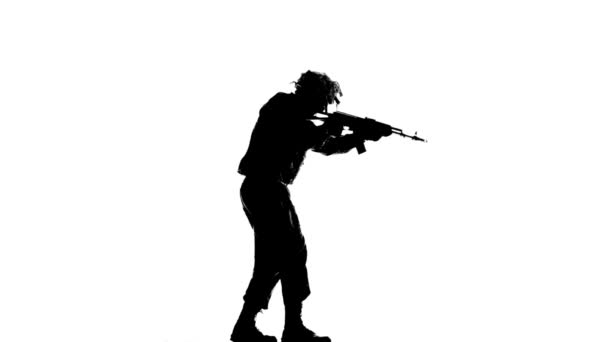 Az ember lassan sétál egy pisztollyal a kezében. Sziluettjét — Stock videók