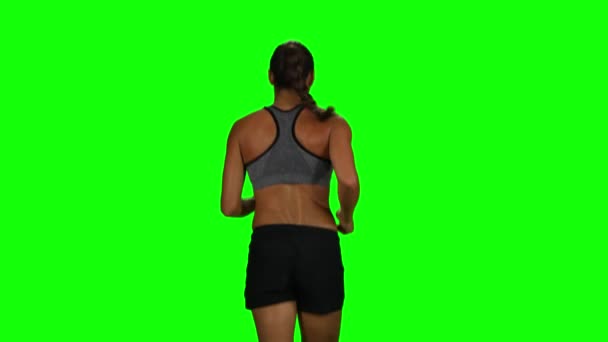 Fit and muscular woman jogging. Back view. Green screen — Stock video