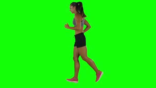 Woman running in sport clothing. Side view. Green screen — ストック動画