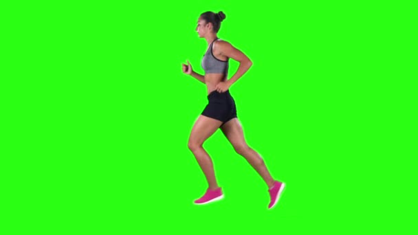 Mujer corriendo con ropa deportiva. Vista lateral. Pantalla verde. Movimiento lento — Vídeos de Stock