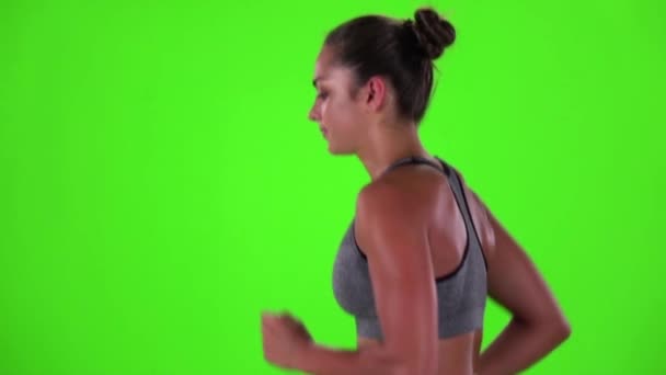 Athletic woman is jogging. Side view. Green screen. Slow motion — Stockvideo