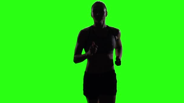 Young woman jogging in a medium frontal shot. Green screen. Slow motion — Stock video