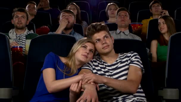 Couple of lovers in the front row watching a movie at the cinema — Stock Video