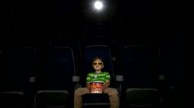 Küçük çocuk bir sinemada 3d gözlük film izlerken gülümsüyor