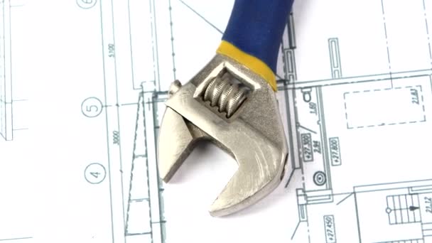 Adjustable wrench on building plan, scheme, rotation, close up — Stock Video