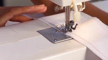 Beyaz kumaş üzerine kırmızı iplik dikiş var. Yakın çekim
