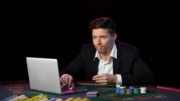 Ο άνθρωπος που κάθεται σε ένα φορητό υπολογιστή και να παίζει στο online καζίνο. Κοντινό πλάνο — Αρχείο Βίντεο