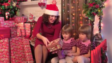 Bir Noel ağacı, çocuklar, annemle yakınındaki mutlu aile sunar, ahşap arka plan