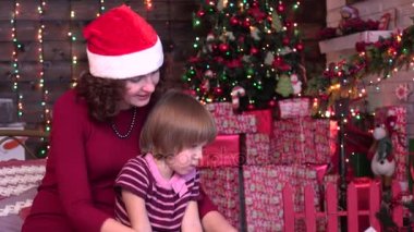 Güzel anne görüntüleri bir kitapta onun sevimli küçük kız, xmas arka plan için gösterilen