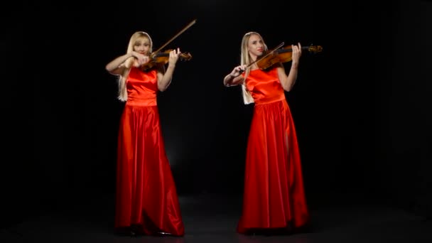 Deux filles blondes jouant du violon. Studio. Fond noir — Video