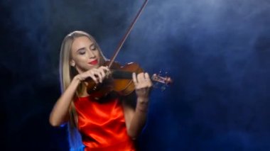 Keman çalmaya Kırmızı elbiseli kadın. Stüdyo. Duman