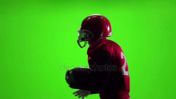 Αθλητής στην κόκκινη στολή με μια μπάλα. Αργή κίνηση. Πλαϊνή όψη. Πράσινη οθόνη — Αρχείο Βίντεο