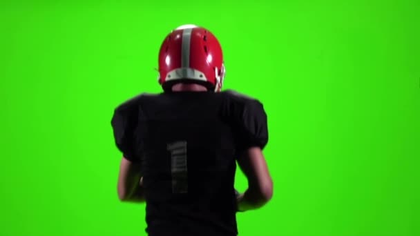 O atleta com a bola e o capacete. Movimento lento, tela verde — Vídeo de Stock