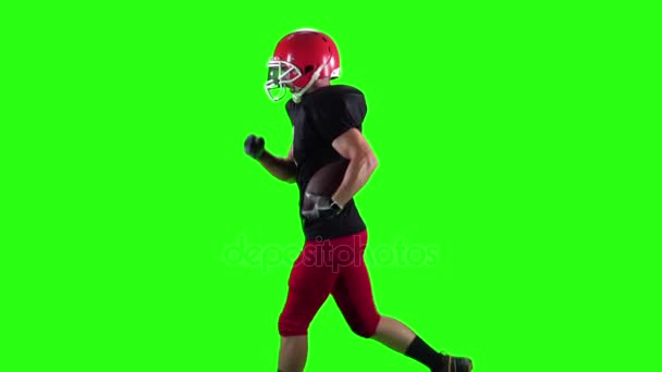両手でボールを持って走るラグビー選手。緑色の画面 — ストック動画