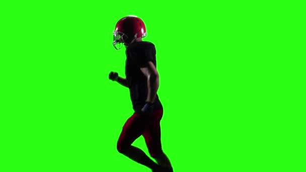 Jugador de rugby corriendo en el casco rojo. Pantalla verde. Movimiento lento — Vídeo de stock