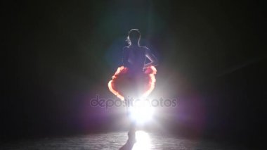 Profesyonel dansçı olarak güzel bir siluet stüdyo beyaz aydınlatmalı, karanlık bir arka plan üzerinde elbise