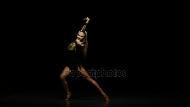 Menina dançando latim em um estúdio em um fundo escuro — Vídeo de Stock