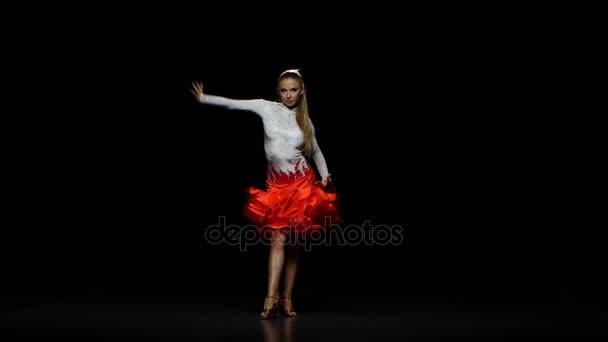 Chica bailando latín en un estudio sobre un fondo oscuro — Vídeos de Stock