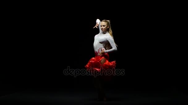 Дівчина танцює ча-ча в студії на темному фоні — стокове відео