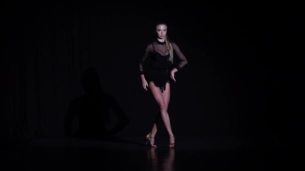 Девушка танцует ча-ча-ча элементы в студии, черный фон. Медленное движение — стоковое видео