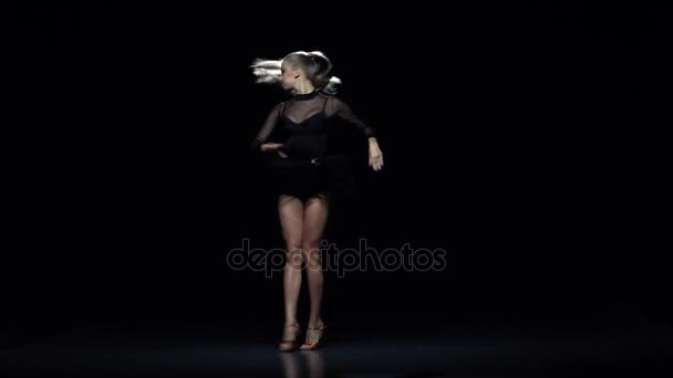 Menina dançando ha-cha-cha no estúdio, fundo preto. Movimento lento — Vídeo de Stock