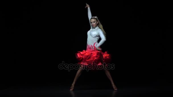 Чарівна дівчина танцює елементи ча-ча-ча, темний фон. Повільний рух — стокове відео