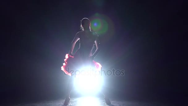 Mädchen tanzen Samba auf dunklem Hintergrund mit hellem Illuminator. Zeitlupe — Stockvideo
