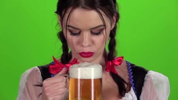 Girl blowing in glasses with beer bites his lip. Slow motion — Stock Video