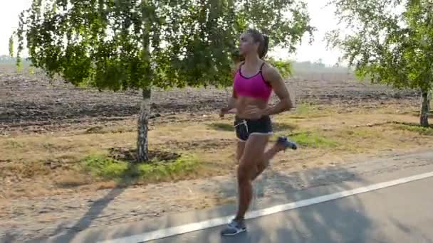 Verano maratón chica deportiva en un camino de campo. Movimiento lento — Vídeos de Stock