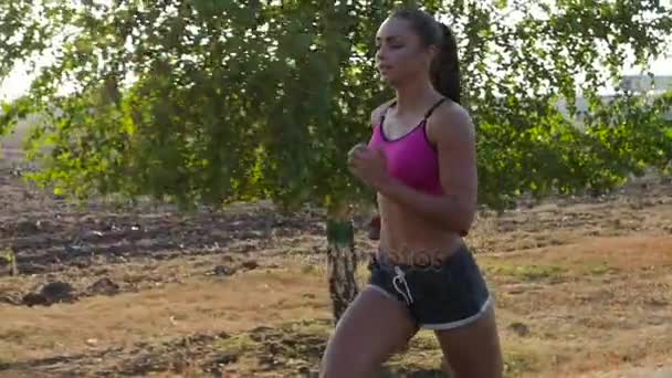 Ochtend joggen mooi meisje op een landweg. Slow motion — Stockvideo