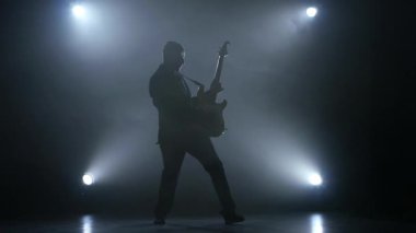 Müzisyen virtüözü üzerinde bir bas gitar dizeleri koparmak. Ağır çekim