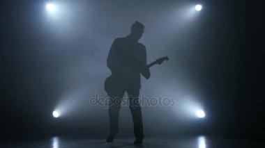 Gitarist elektrik gitar çalıyor. Duman arka plan. Stüdyo. Ağır çekim