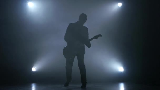 Guitarrista toca la guitarra eléctrica. Fondo de humo. Estudio. Movimiento lento — Vídeo de stock