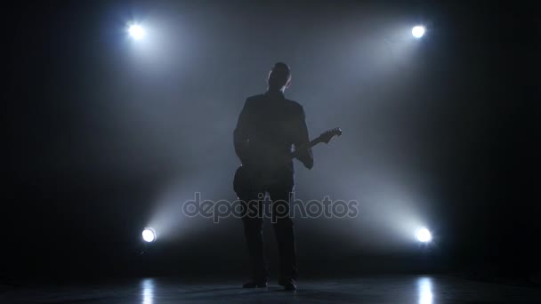 Gitarist in een donkere studio speelt een snelle melodie — Stockvideo