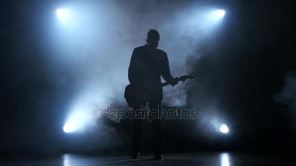 Un uomo che suona una melodia lenta alla chitarra. Smoke studio — Video Stock