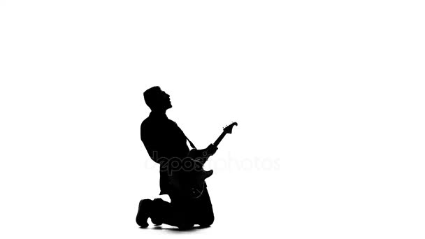 그의 무릎에 전기 베이스 기타 연주 음악가. 실루엣 — 비디오