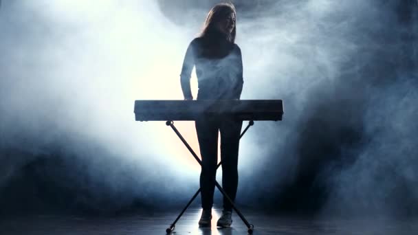 A zenész egy elektronikus zongora gyors zene lejátszása. Füst. Stúdió — Stock videók