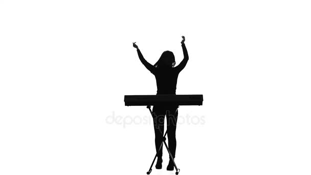 Woman is dancing for the electronic piano. Silhouette. Studio — Stock Video