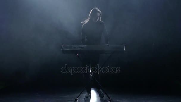 Zenész nő zongorázni. Sötét háttér előtt. Lassú mozgás — Stock videók