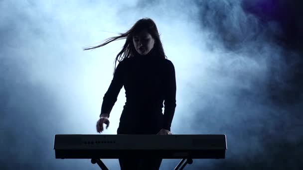 電子ピアノ。演奏に合わせて踊る女性。スローモーション。スタジオ — ストック動画