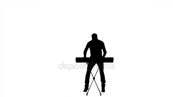 Silhouet van een man die spelen op electronische toetsenbord. Slow motion — Stockvideo