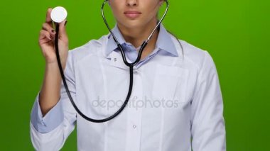 Stetoskop tıbbi beyaz cüppe ve forması, konsantre güzel manikür, ciddi parmakları giymiş, dinleme doktor kız bel, yeşil ekran vurdu görülen yarım, ön yüz