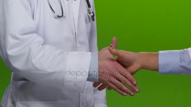 Un apretón de manos de dos doctores vestidos de blanco. Pantalla verde. De cerca. — Vídeos de Stock