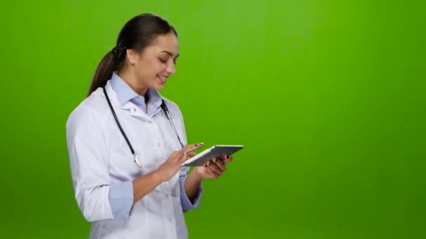 Infirmière navigue l'information sur la tablette pc et sourires mignons — Video
