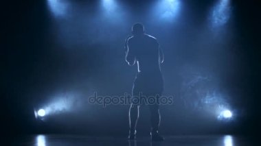 Boxer erkek arka ışık ile karanlık bir stüdyoda koçluk