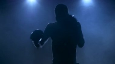 Smoky Stüdyoda sporcu boksu. Karanlık bir arkaplanda siluet