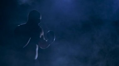 Mücadele öncesi egzersiz. Güçlü darbeler boksör. Siluet stüdyo