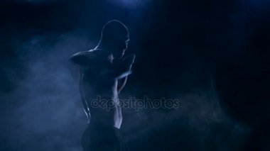 Güçlü darbeler boksör. Mücadele öncesi egzersiz. Siluet stüdyo