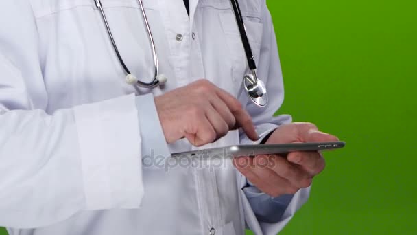 医師は、タブレット pc で患者情報を書き込みます。緑色の画面 — ストック動画